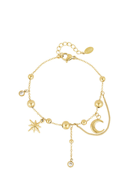 Gold celestial charm bracelet with moon, star, and bead charms on white background