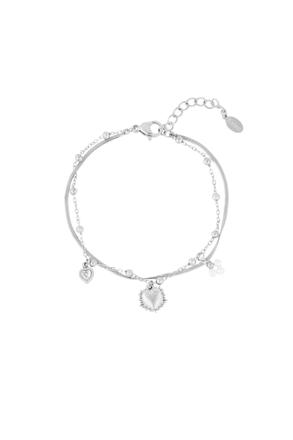 Close-up of silver double charm bracelet featuring heart pendants and pearl clusters on white background