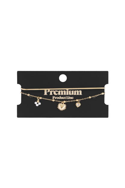 Gold double charm bracelet displayed on black Premium Product Line card showing adjustable clasp