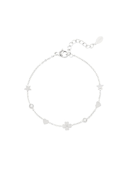 Silver-tone charm bracelet with star, heart, four-leaf clover and crystal accents laid flat with lobster clasp and adjustable links