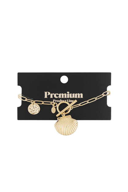 Gold charm bracelet displayed on black Premium Product Line card