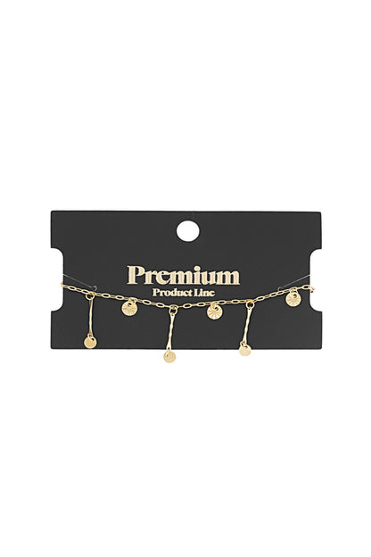 Gold coin charm bracelet displayed on black 'Premium Product Line' card packaging