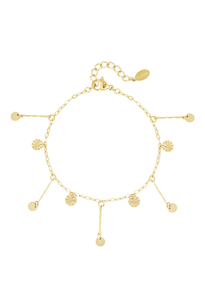 Gold coin charm bracelet laid flat showcasing delicate dangling sunburst and smooth coins on chain