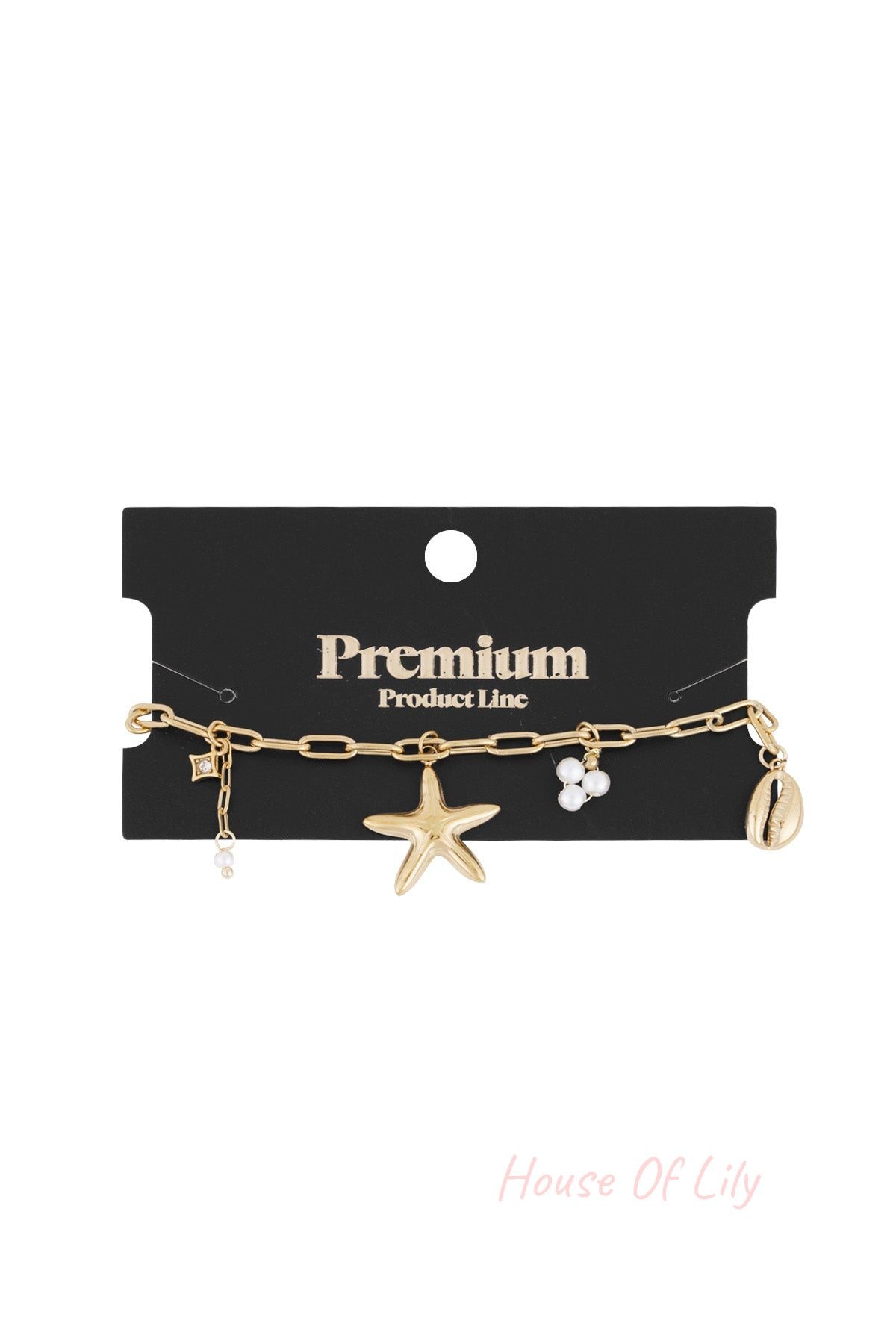 Gold-tone seaside charm bracelet displayed on black card labelled Premium Product Line