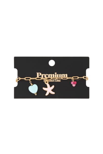Gold charm bracelet displayed on black 'Premium Product Line' packaging showing starfish, heart, and bead charms