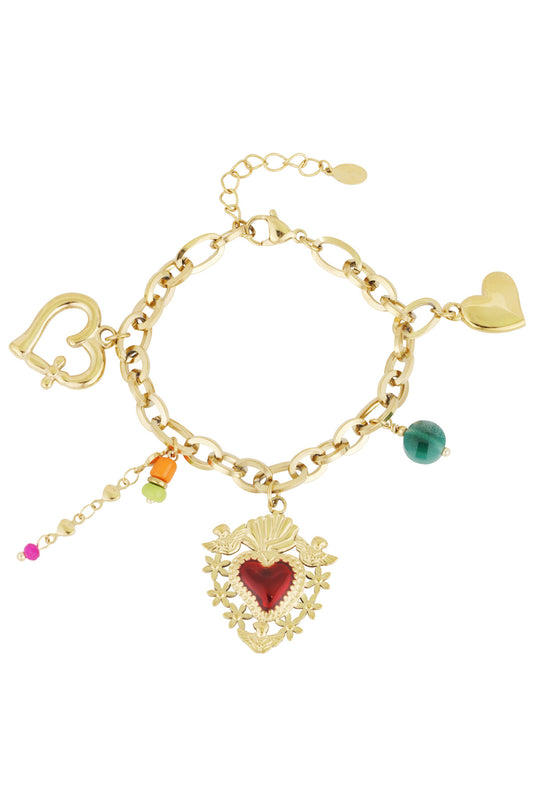 Gold charm bracelet with red heart central charm, colorful beads, and heart-shaped clasp laid flat on white background