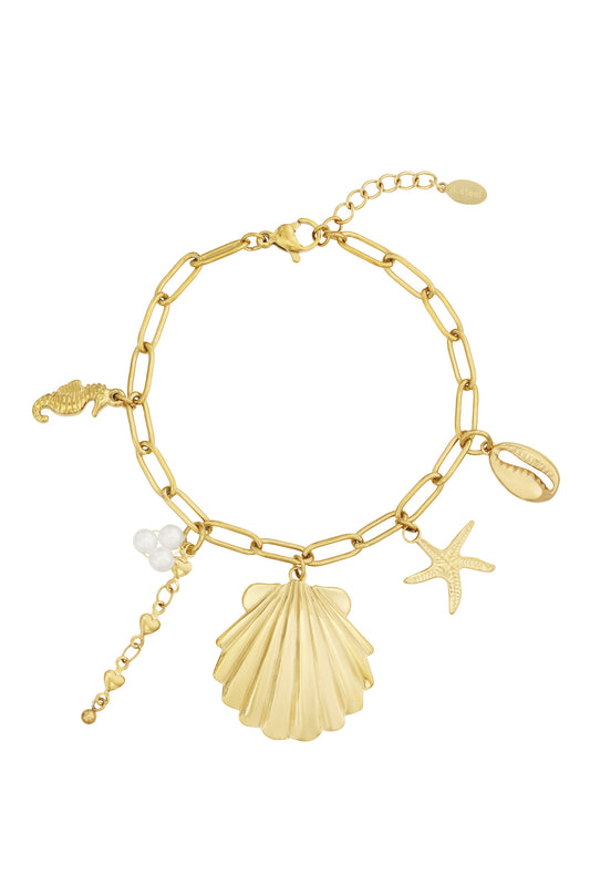 Golden chain-link charm bracelet laid flat showing shell, starfish, seahorse, cowrie shell, and pearl cluster charms