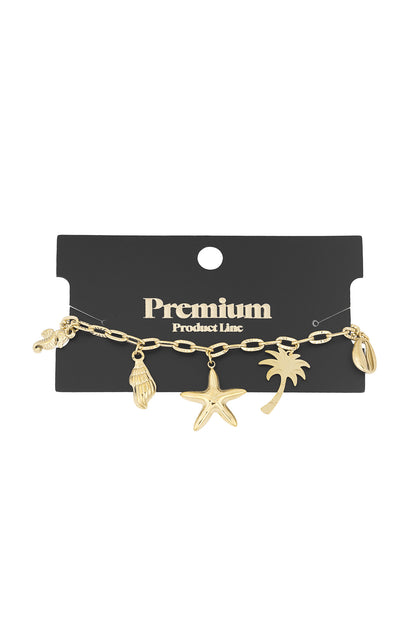 Gold charm bracelet displayed on black premium product card showing seaside themed charms clearly