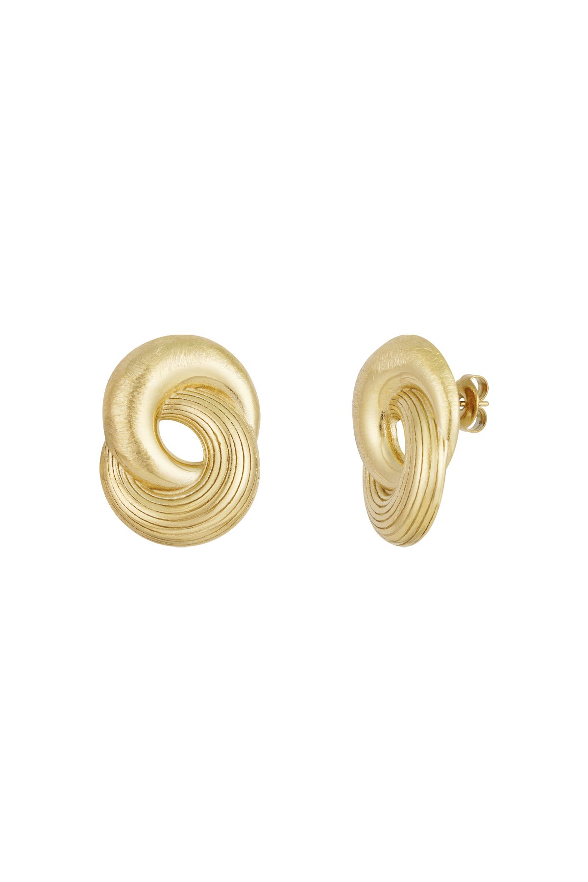 Close-up of a pair of gold twist statement stud earrings with smooth and grooved texture