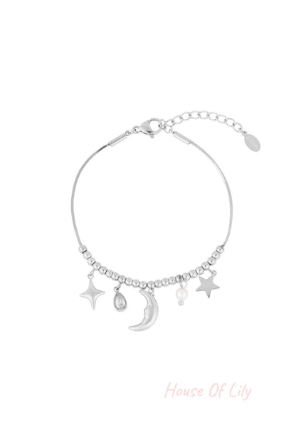 Silver celestial charm bracelet with moon, stars, pearl, and teardrop crystal charms on a beaded chain with adjustable clasp