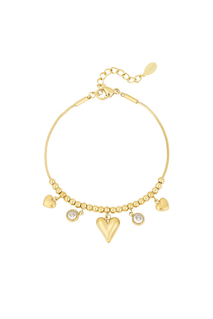 Gold heart bead bracelet with dangling heart charms and crystal accents on white background
