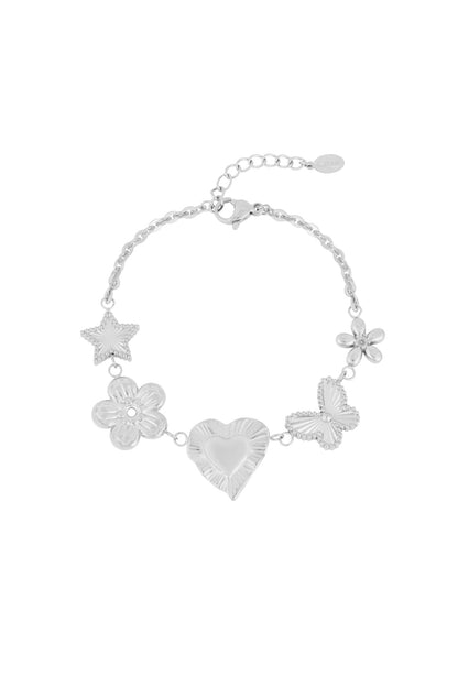 Silver charm bracelet with star, flower, heart, butterfly, and blossom motifs on white background