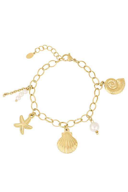 Gold chain charm bracelet with starfish, scallop shell, nautilus shell and pearl charms on white background