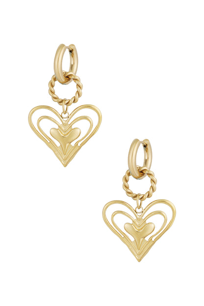 Gold twisted hoop earrings with layered open heart charm on white background