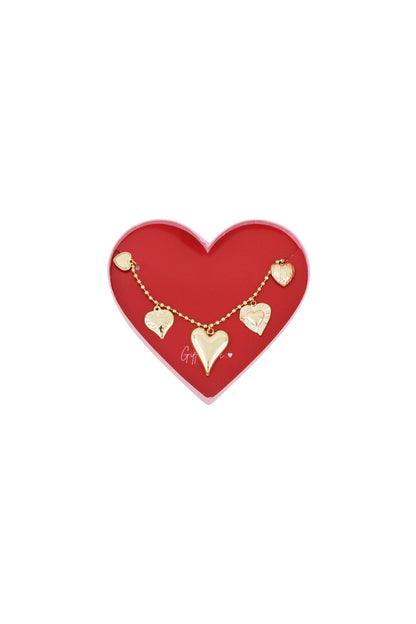 Gold heart charm bracelet with five unique heart-shaped pendants displayed on red heart-shaped box
