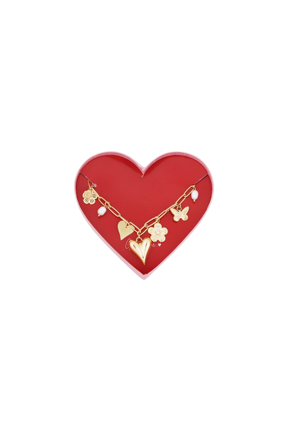Golden charm link bracelet displayed on a red heart-shaped box featuring flower, butterfly, heart charms and pearl accents
