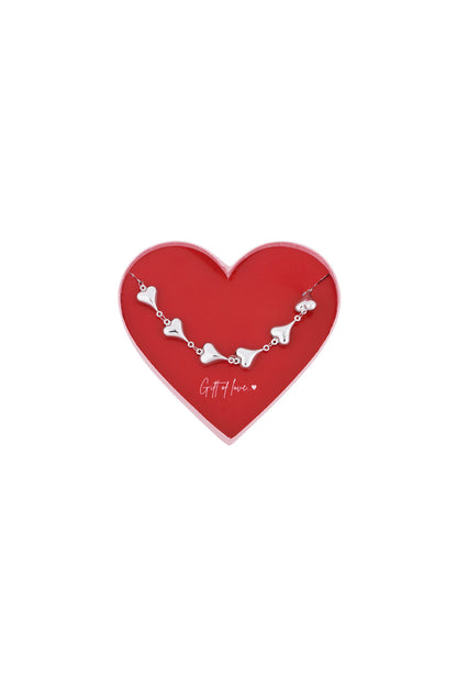 Silver heart chain bracelet displayed inside a red heart-shaped gift box with 'Gift of love' inscription