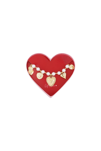 Gold-tone beaded bracelet with pearls and heart charms displayed in a red heart-shaped box
