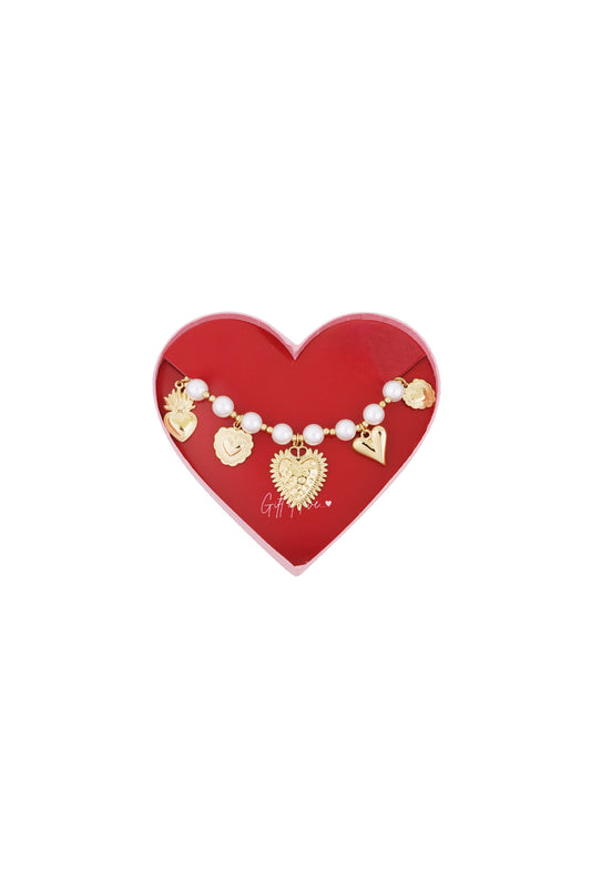 Gold-tone beaded bracelet with pearls and heart charms displayed in a red heart-shaped box