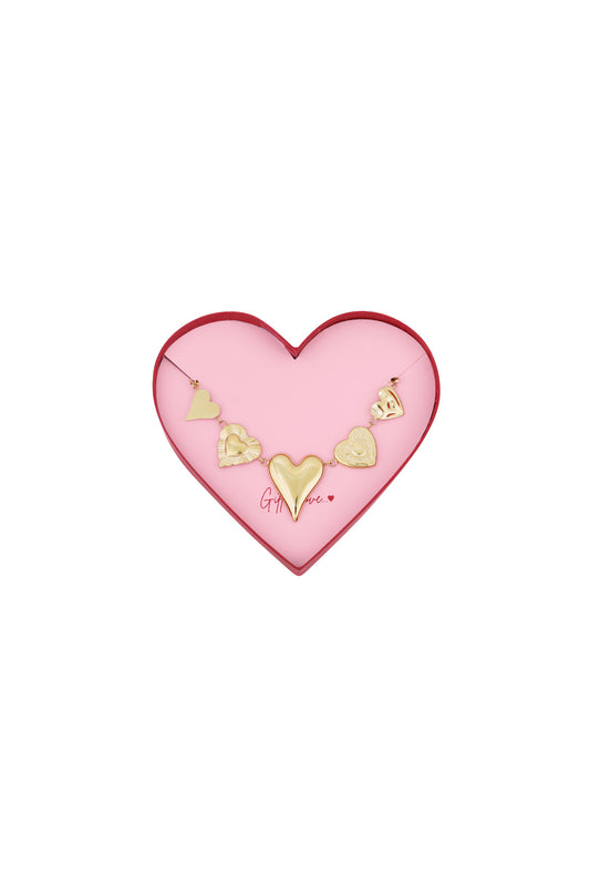 Gold heart charm bracelet with five distinct heart-shaped charms displayed inside a pink heart shaped box with red edges and the phrase 'Gift of Love'