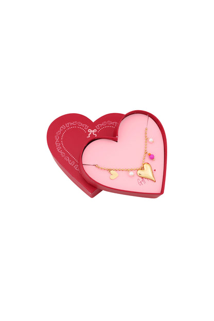 Opened heart-shaped gift box showing gold heart charm bracelet with pearls and pink bead inside