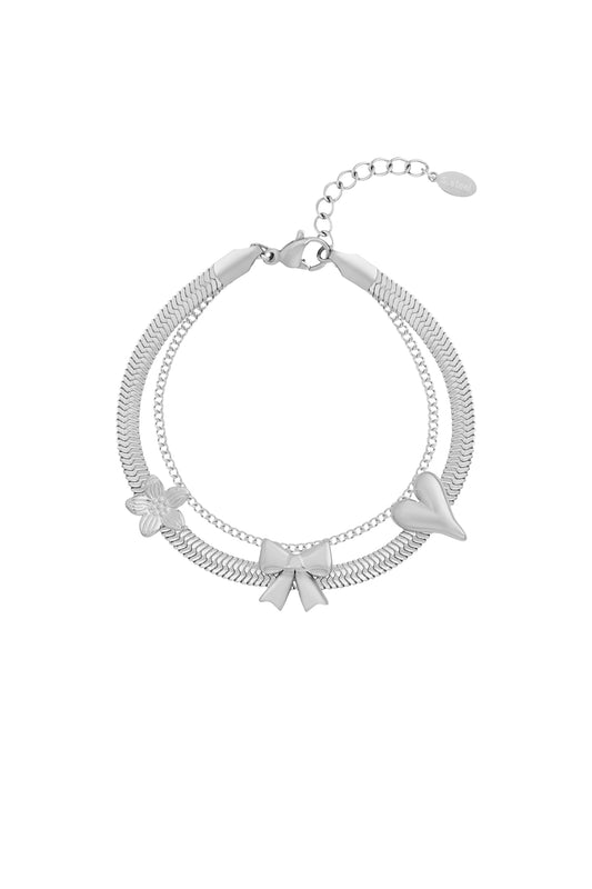 Silver stainless steel charm bracelet with bow, heart, and flower charms on white background
