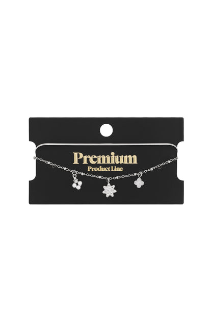 Silver floral charm bracelet on black packaging card with Premium Product Line label