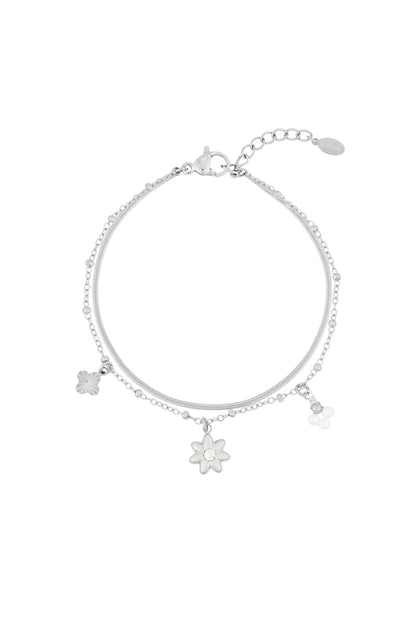 Dainty silver-tone double-chain bracelet with flower, pearl-cluster, and clover charms.