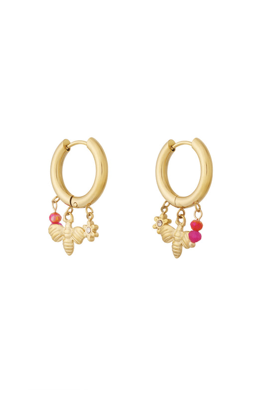Gold charm hoop earrings with bee, flower charms and red-pink beads on white background