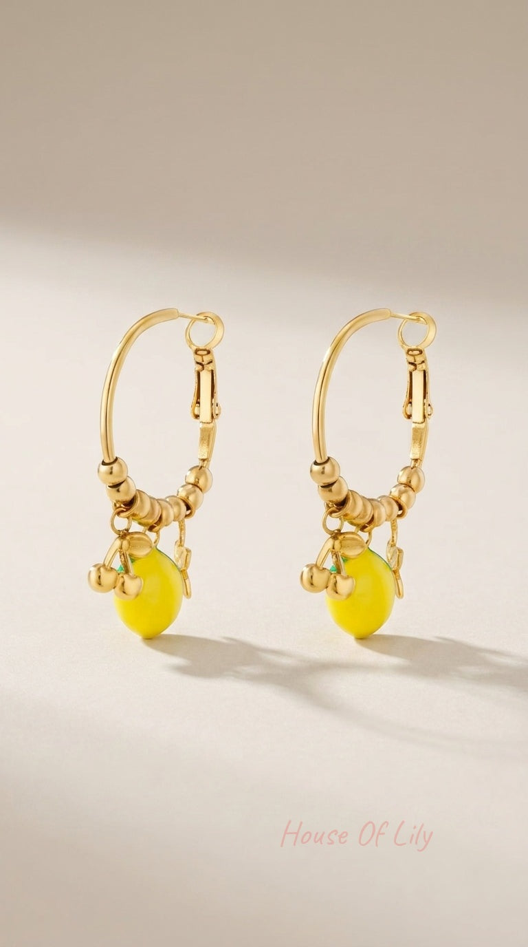 Gold hoop earrings featuring beaded detailing with yellow lemon and small gold cherry charms.