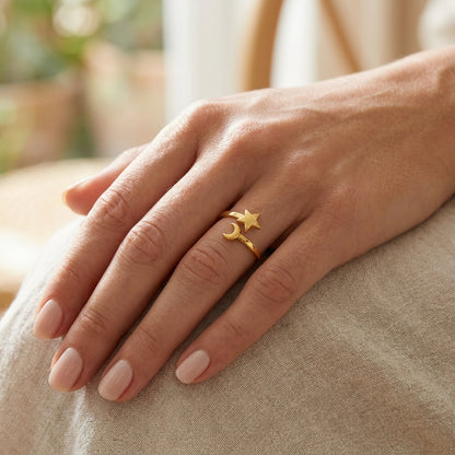 Gold Celestial Mood Ring on a finger, featuring an open-band design with a small star and crescent moon charm.