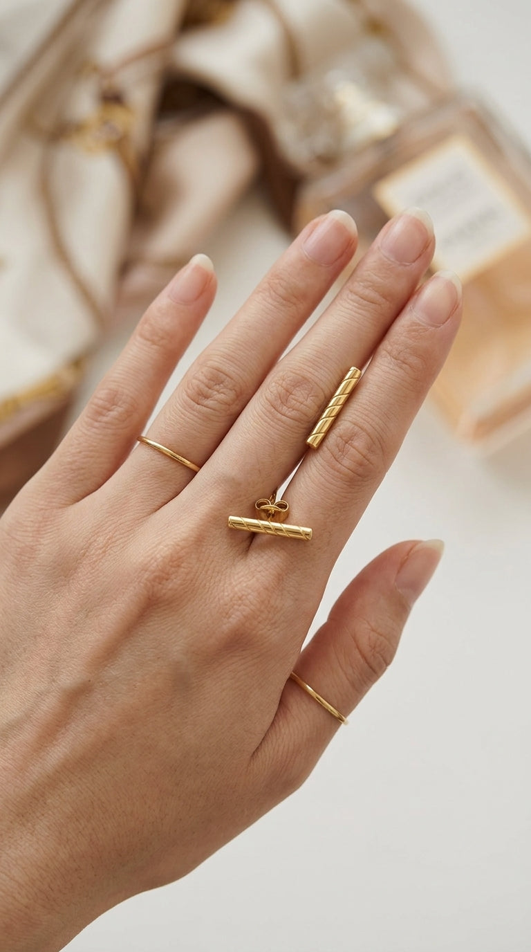 Gold-tone bar ring and matching earring set featuring a diagonal ribbed texture, styled with two slim stacking bands.