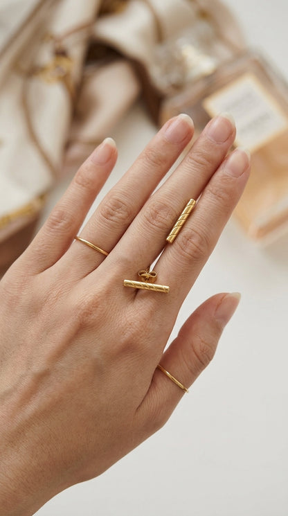 Gold-tone bar ring and matching earring set featuring a diagonal ribbed texture, styled with two slim stacking bands.