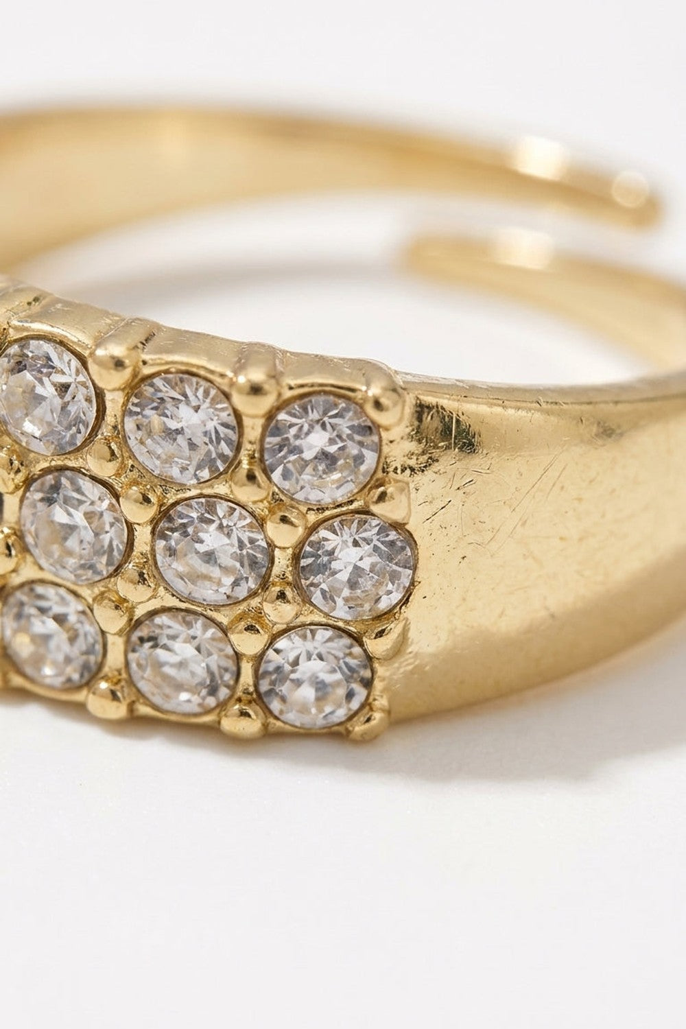 Gold ring featuring a square setting paved with clear round rhinestones in a 3x3 grid.