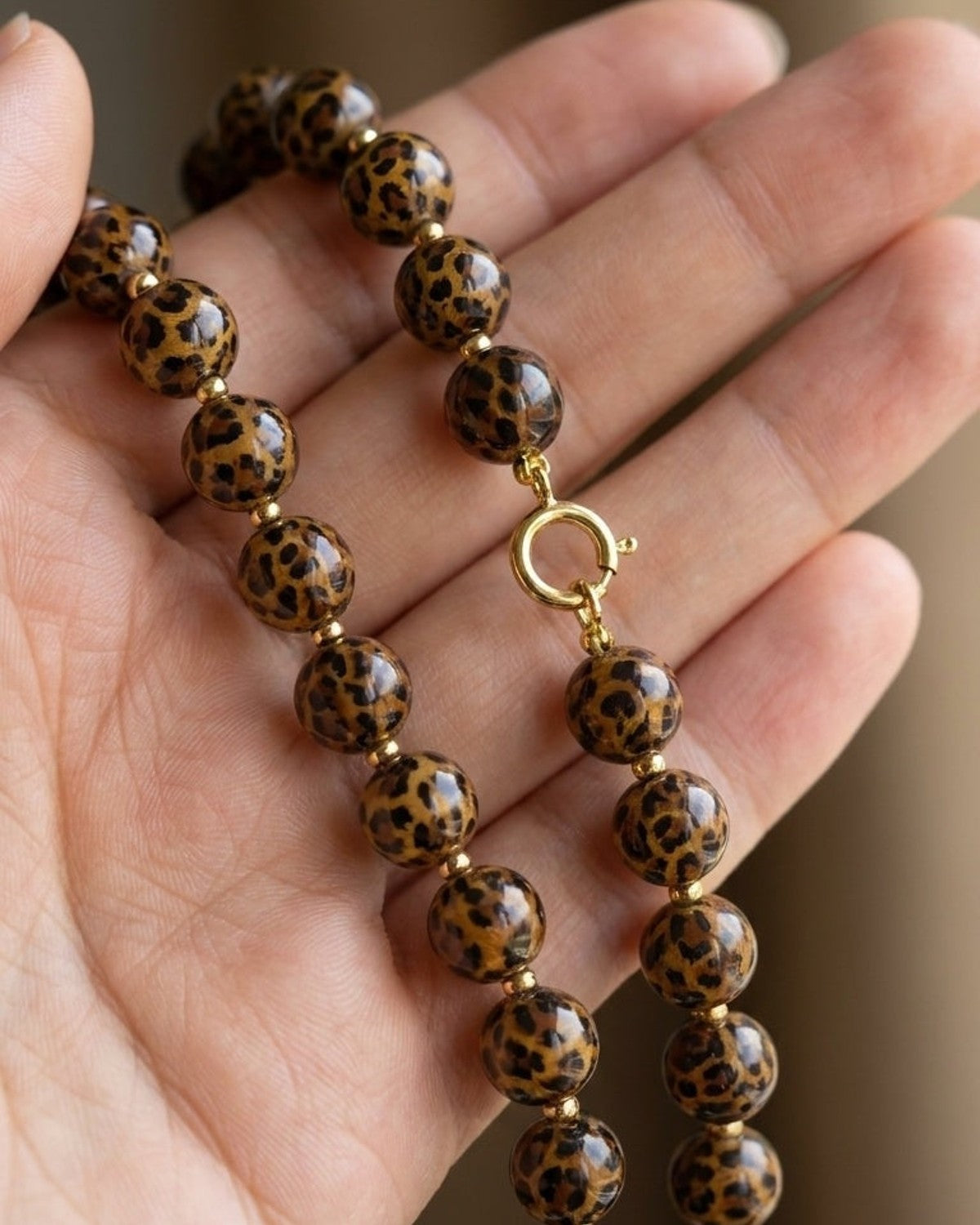 House Of Lily's beaded necklace features round brown and black leopard print beads on a gold-tone clasp.