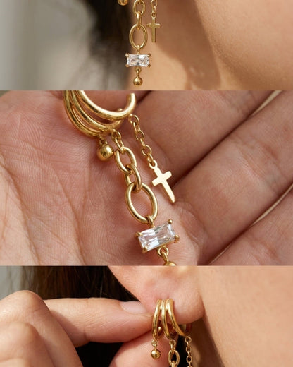 Gold Cross Drop Statement Earrings featuring triple hoops, dangling chains, a cross charm, and a baguette-cut crystal.