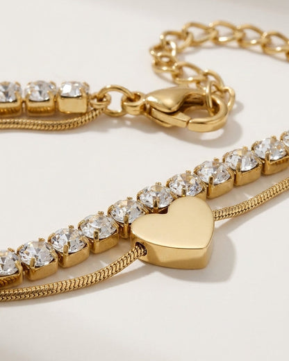 Gold Charm Layered Bracelet with a tennis chain, snake chain, and a polished heart charm.