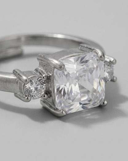 Silver-tone ring featuring a large square rhinestone flanked by smaller round rhinestones in prong settings.