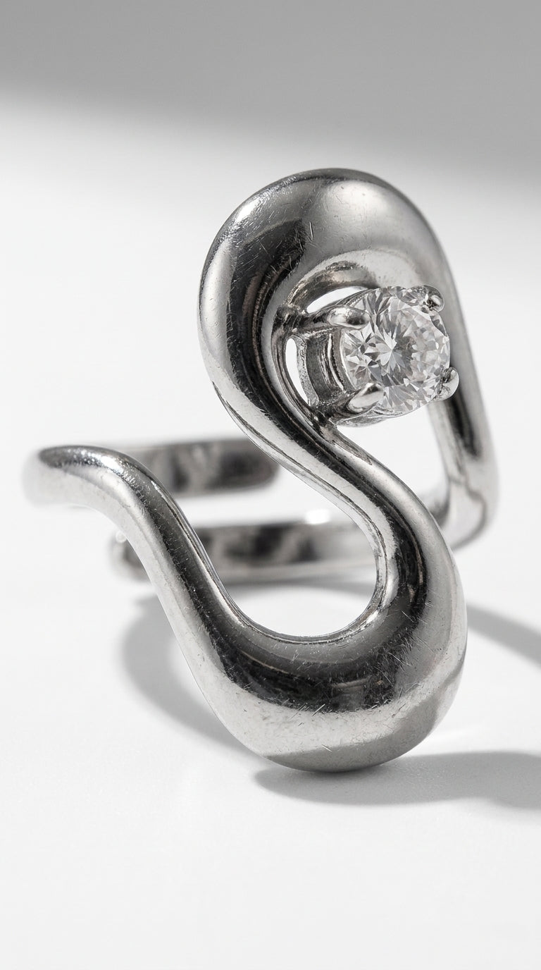 Irregular Statement Ring in polished silver featuring an asymmetric, curved band holding a prong-set round gemstone.