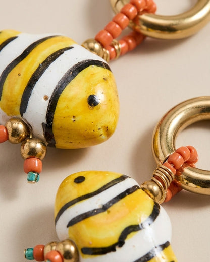 Glass fish bead earrings with yellow, white, and black striped fish, orange seed beads, and gold rings.