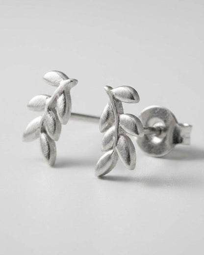Brushed silver leaf-shaped stud earrings in a delicate botanical style.