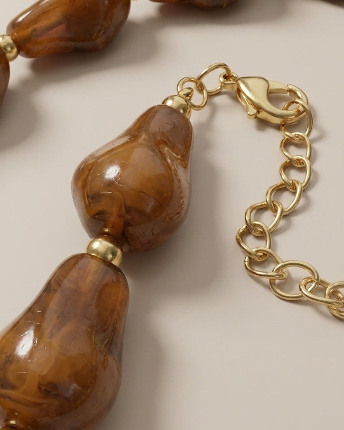 Chunky brown marbled resin bead necklace with gold-tone metal spacers and lobster clasp.
