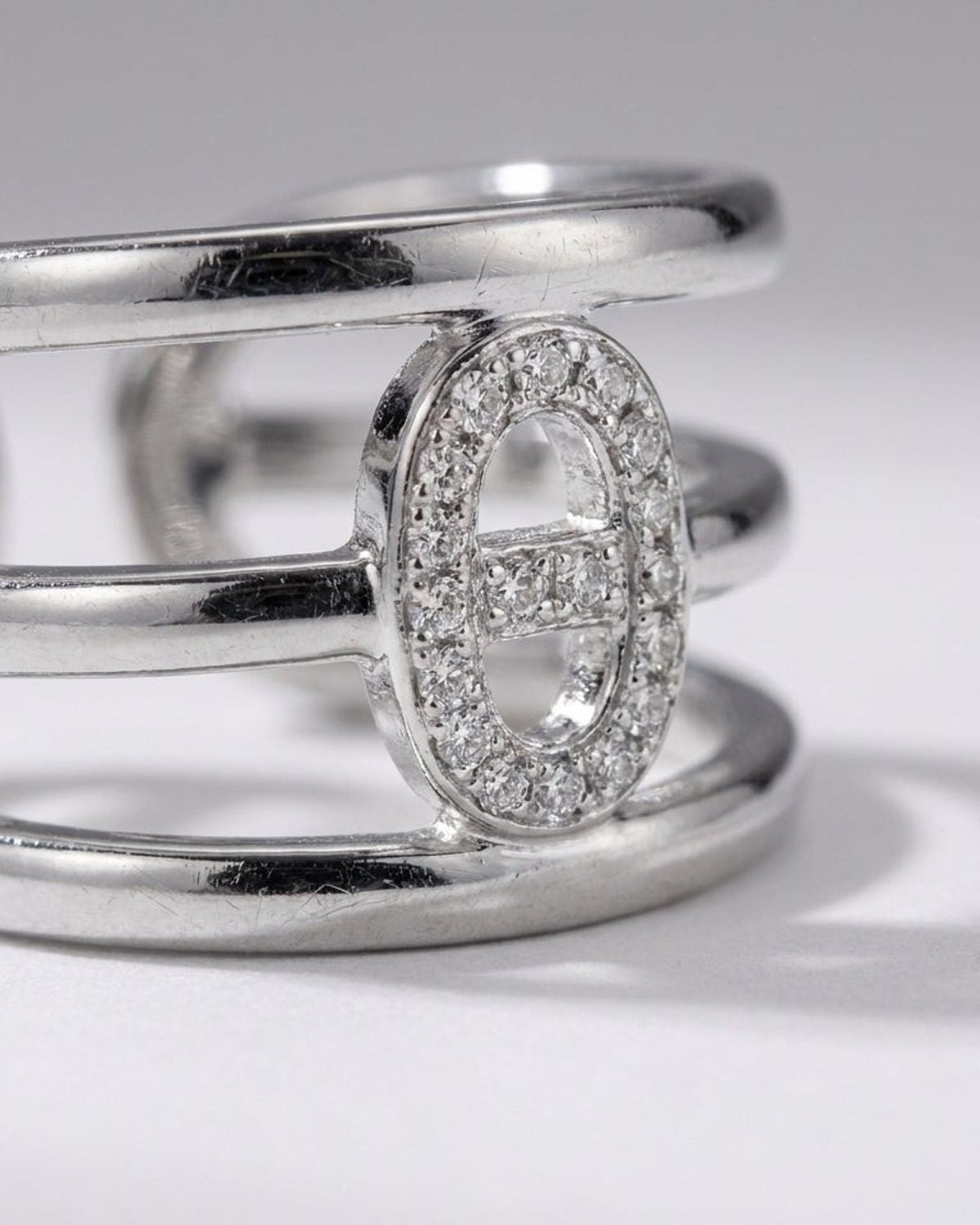 Silver multi-band statement ring featuring an elliptical centerpiece encrusted with small clear stones.
