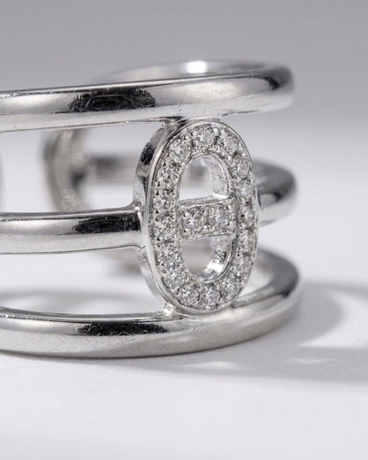 Silver multi-band statement ring featuring an elliptical centerpiece encrusted with small clear stones.
