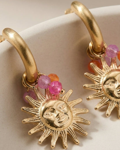 Gold hoop earrings with dangling sun charms, adorned with small pink and orange faceted beads.