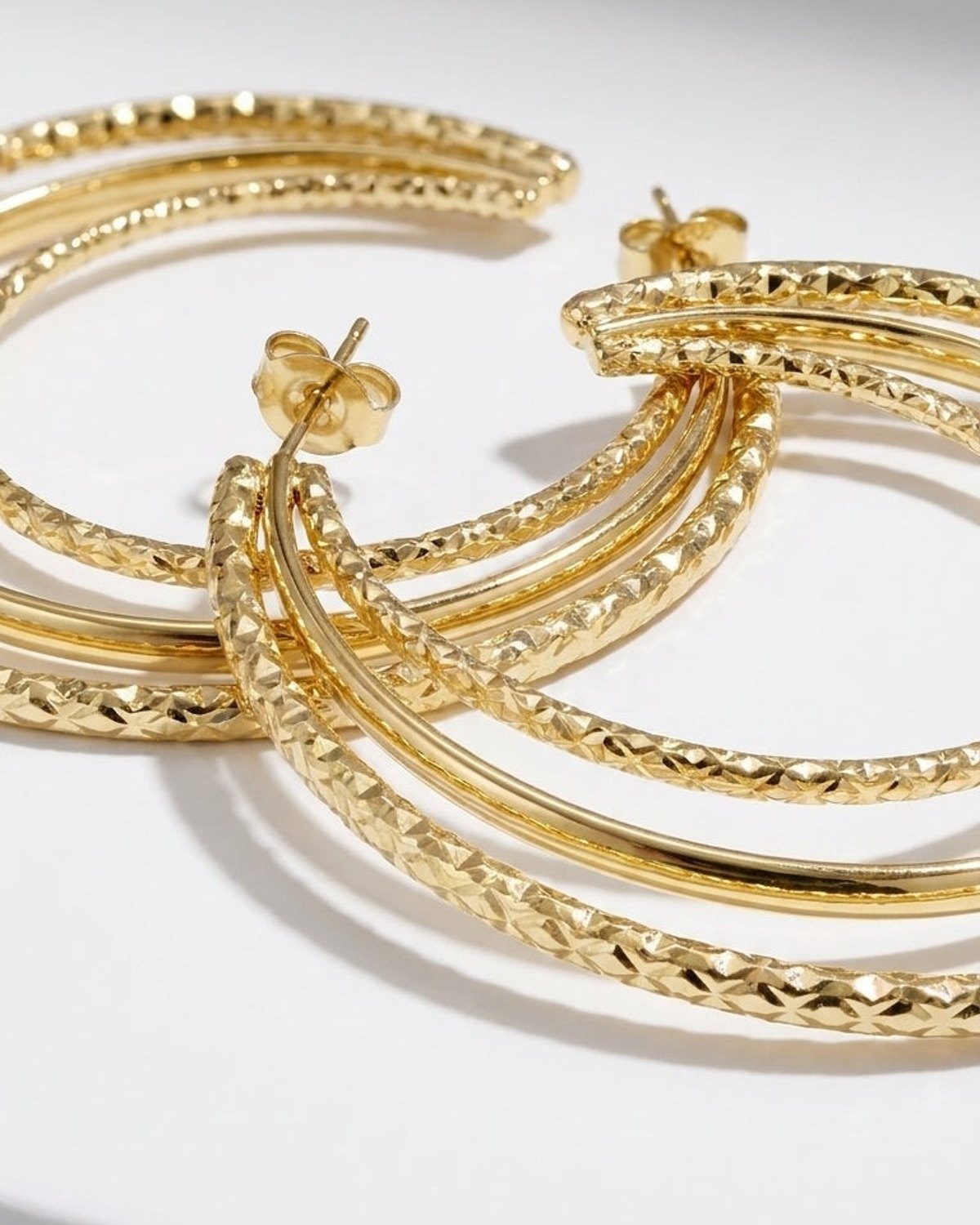 Stacked Aura Gold earrings: multi-strand gold hoop earrings featuring textured and polished finishes.