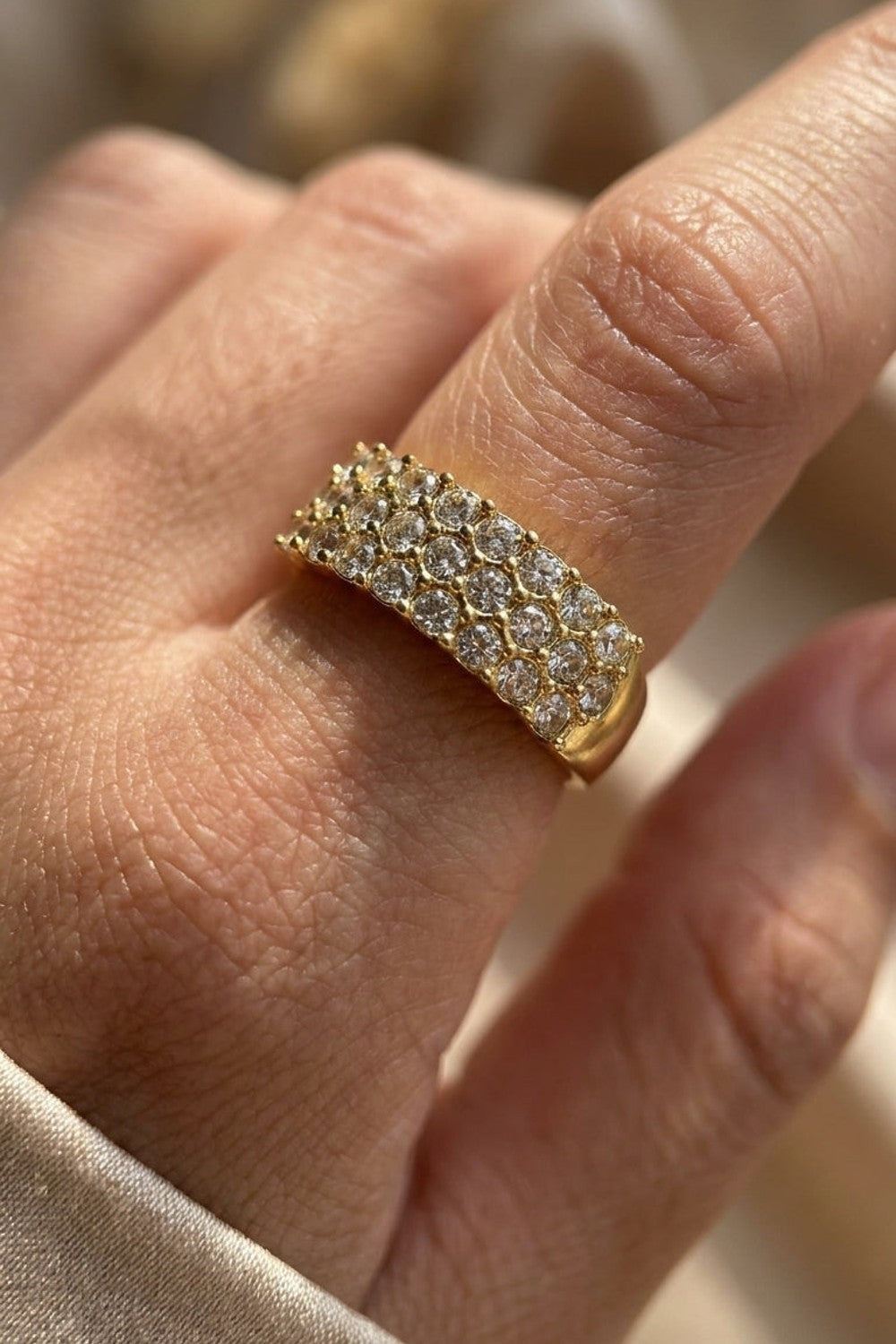 Gold ring featuring three parallel rows of pavé-set rhinestones.