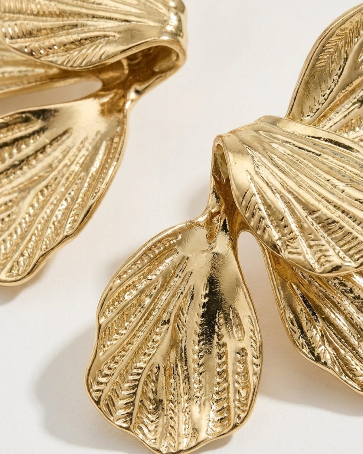 Flower Drop Earrings: Textured gold-toned metal earrings shaped like overlapping flower petals with etched details.