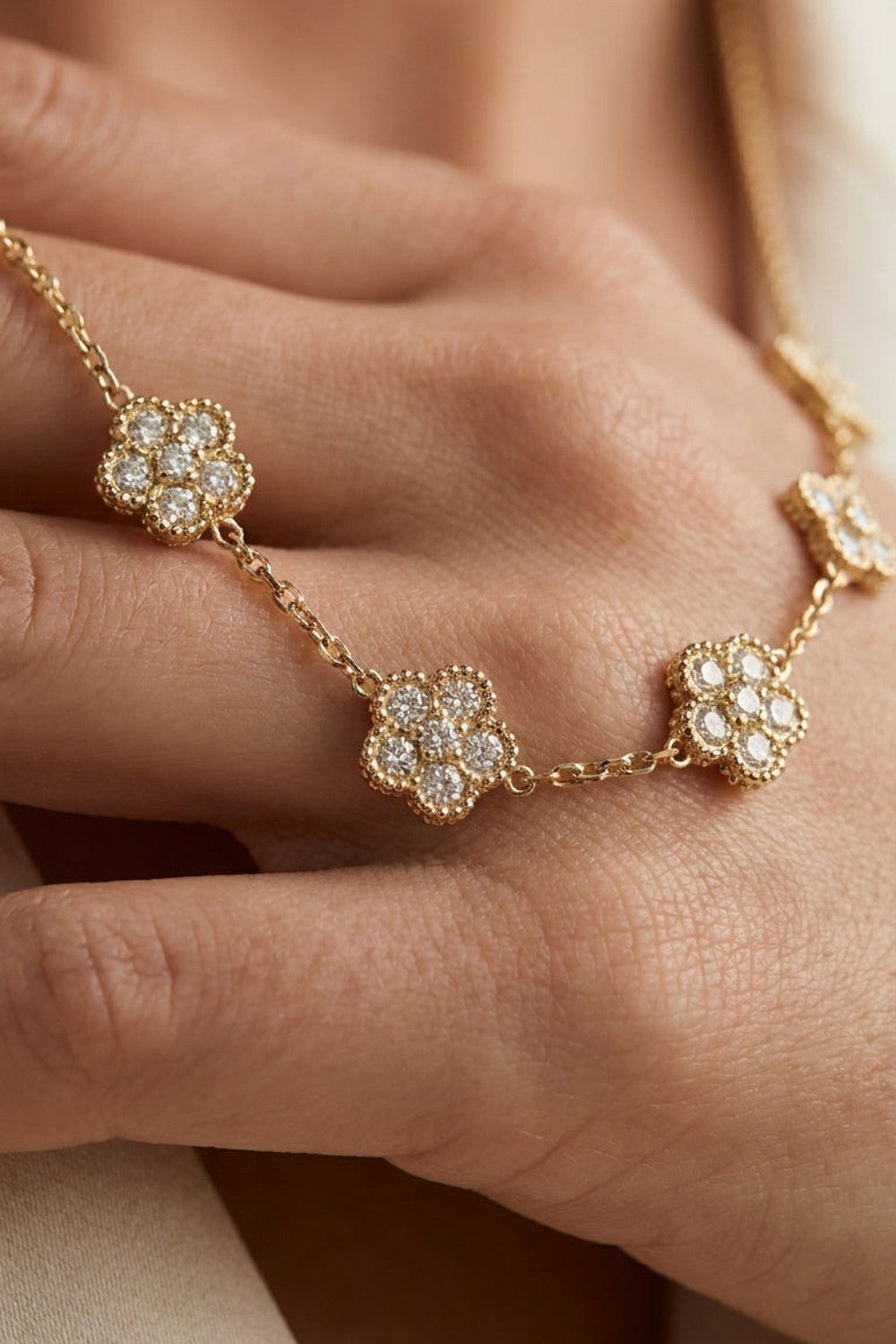 Gold chain necklace featuring multiple floral stations set with sparkling zircon stones.