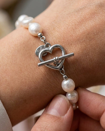 Freshwater pearl bracelet on wrist with a silver heart-shaped toggle clasp.